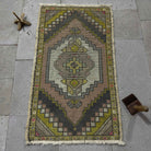 Pink 2' x 3' vintage turkish rug in wool and cotton, shown on the floor.