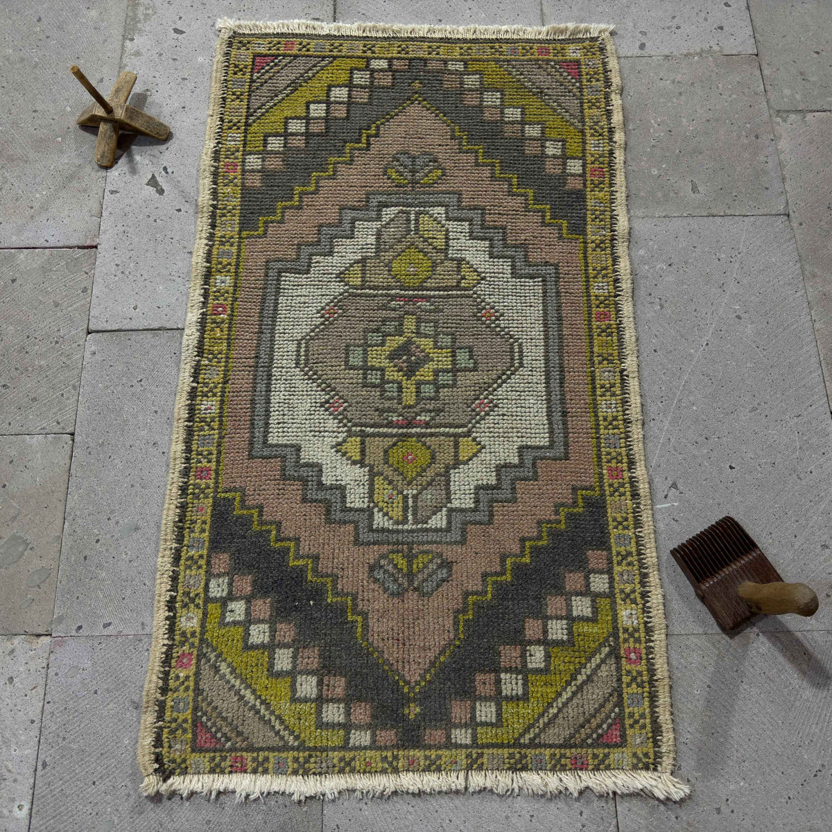 Pink 2' x 3' vintage turkish rug in wool and cotton, shown on the floor.