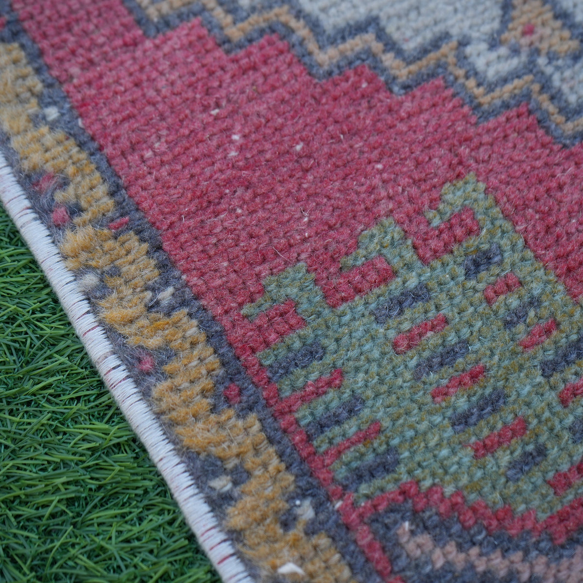 Red 2' x 3' vintage turkish rug in wool and cotton, shown on the floor.