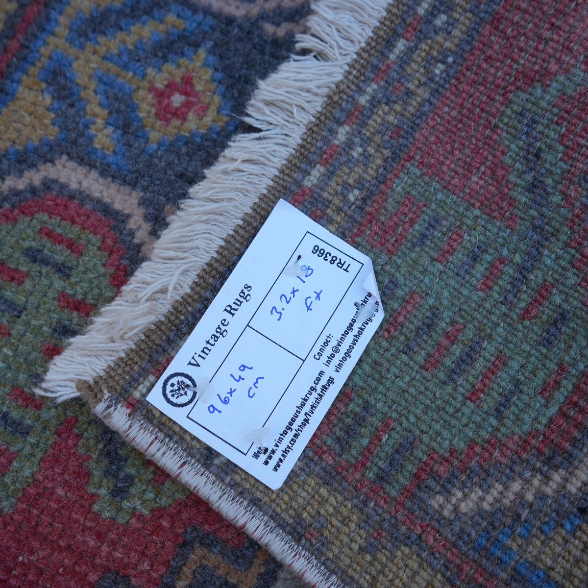 Red 2' x 3' vintage turkish rug from the 1970s with traditional design.