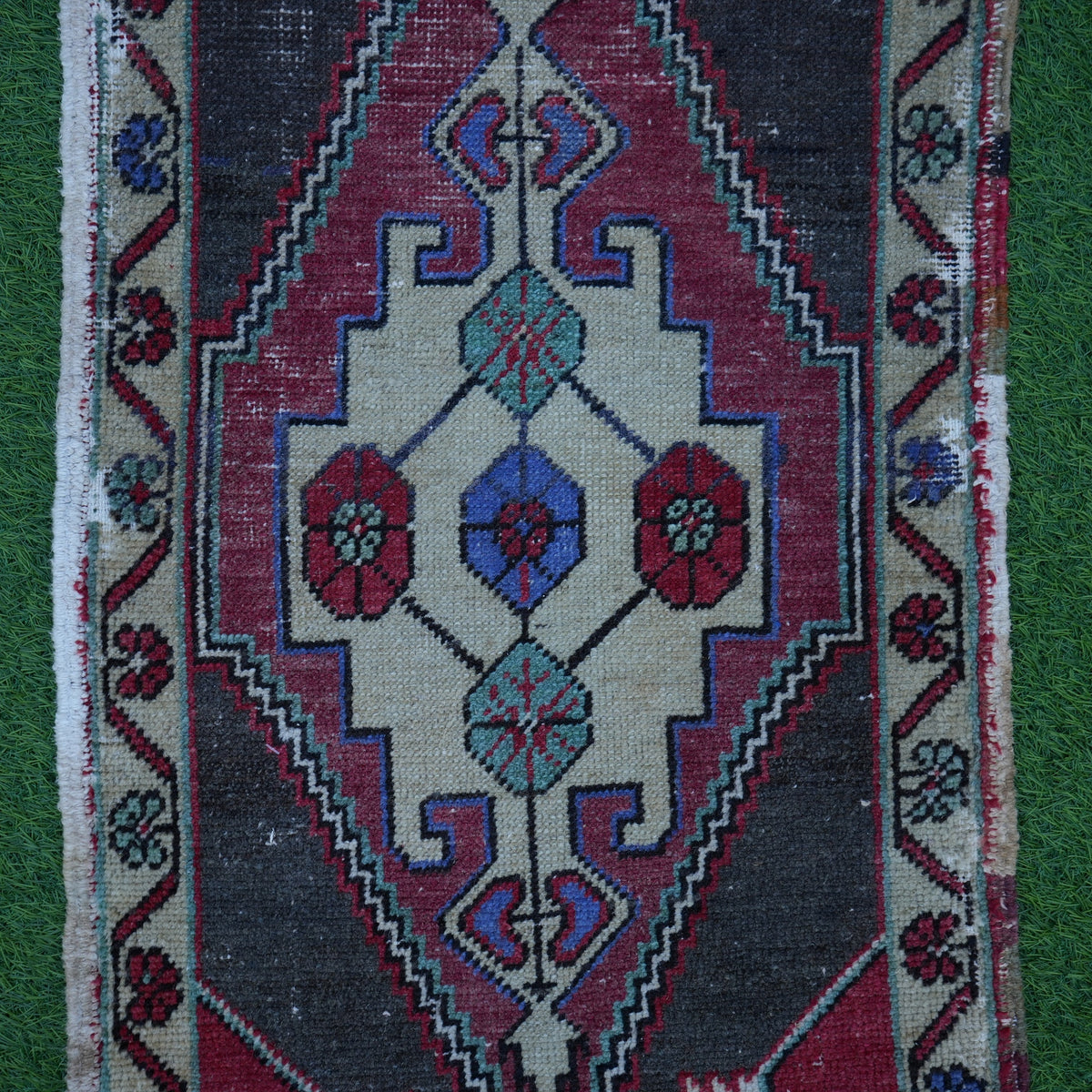 Close-up of the red vintage turkish rug showing traditional details, hand-knotted weave, wool and cotton and low pile.