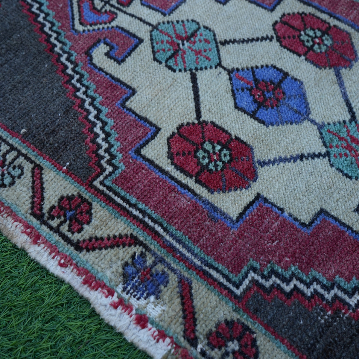 Red 2' x 3' vintage turkish rug in wool and cotton, shown on the floor.