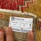 Close-up of the red vintage turkish rug showing traditional details, hand-knotted weave, wool and cotton and low pile.