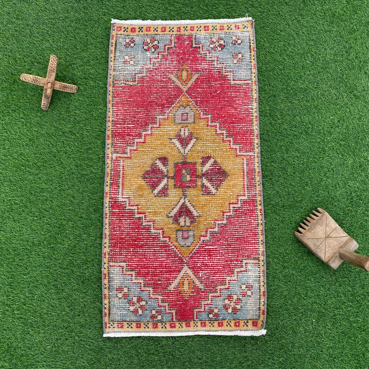 Red 2' x 3' vintage turkish rug in wool and cotton, shown on the floor.