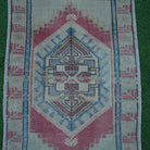 Close-up of the red vintage turkish rug showing traditional details, hand-knotted weave, wool and cotton and low pile.