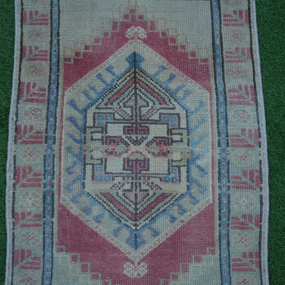 Close-up of the red vintage turkish rug showing traditional details, hand-knotted weave, wool and cotton and low pile.
