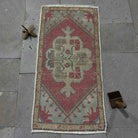Red 2' x 3' vintage turkish rug in wool and cotton, shown on the floor.