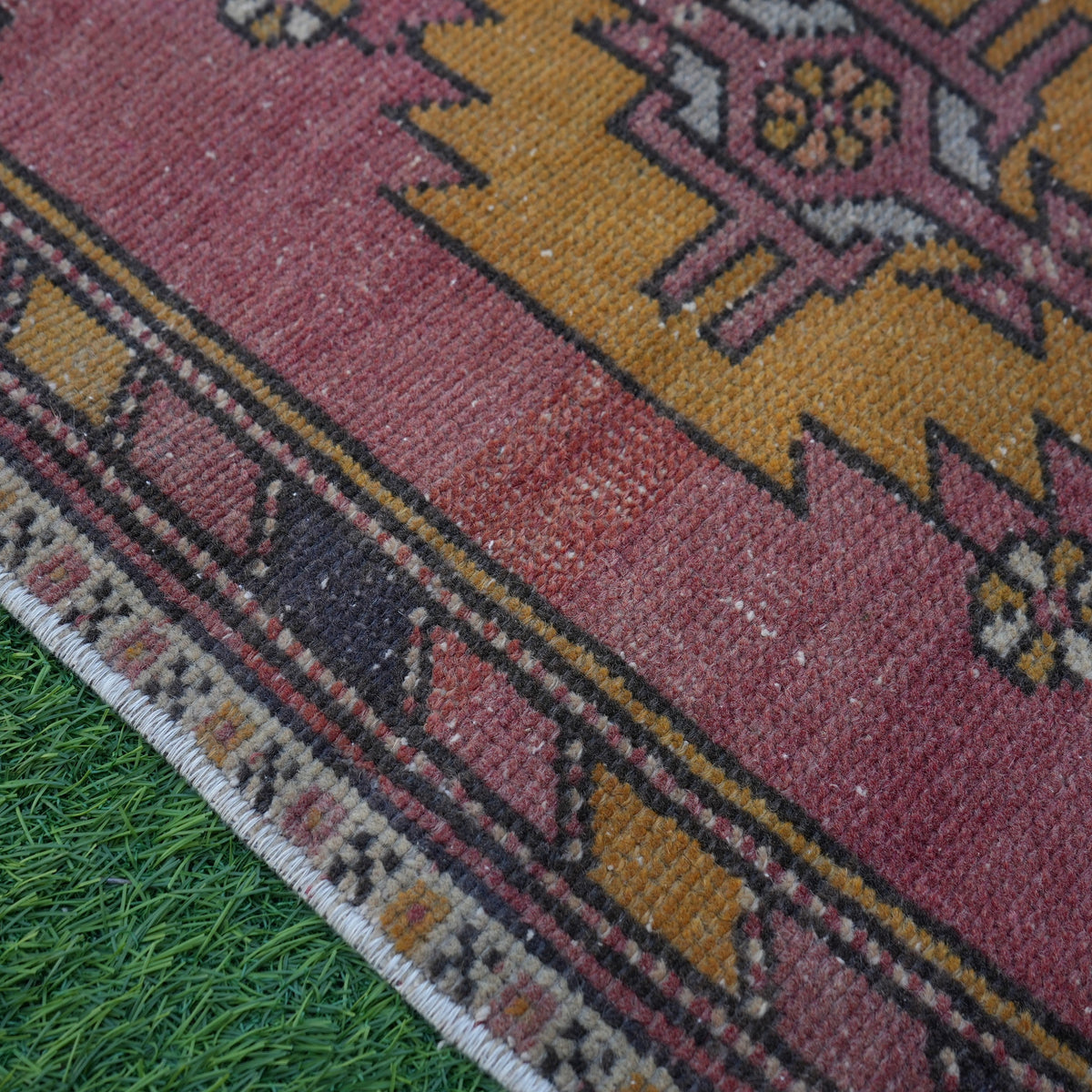Red 2' x 3' vintage turkish rug in wool and cotton, shown on the floor.