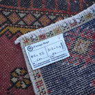 Red 2' x 3' vintage turkish rug from the 1970s with traditional design.