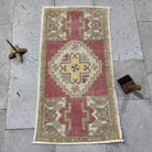 Red 2' x 3' vintage turkish rug in wool and cotton, shown on the floor.