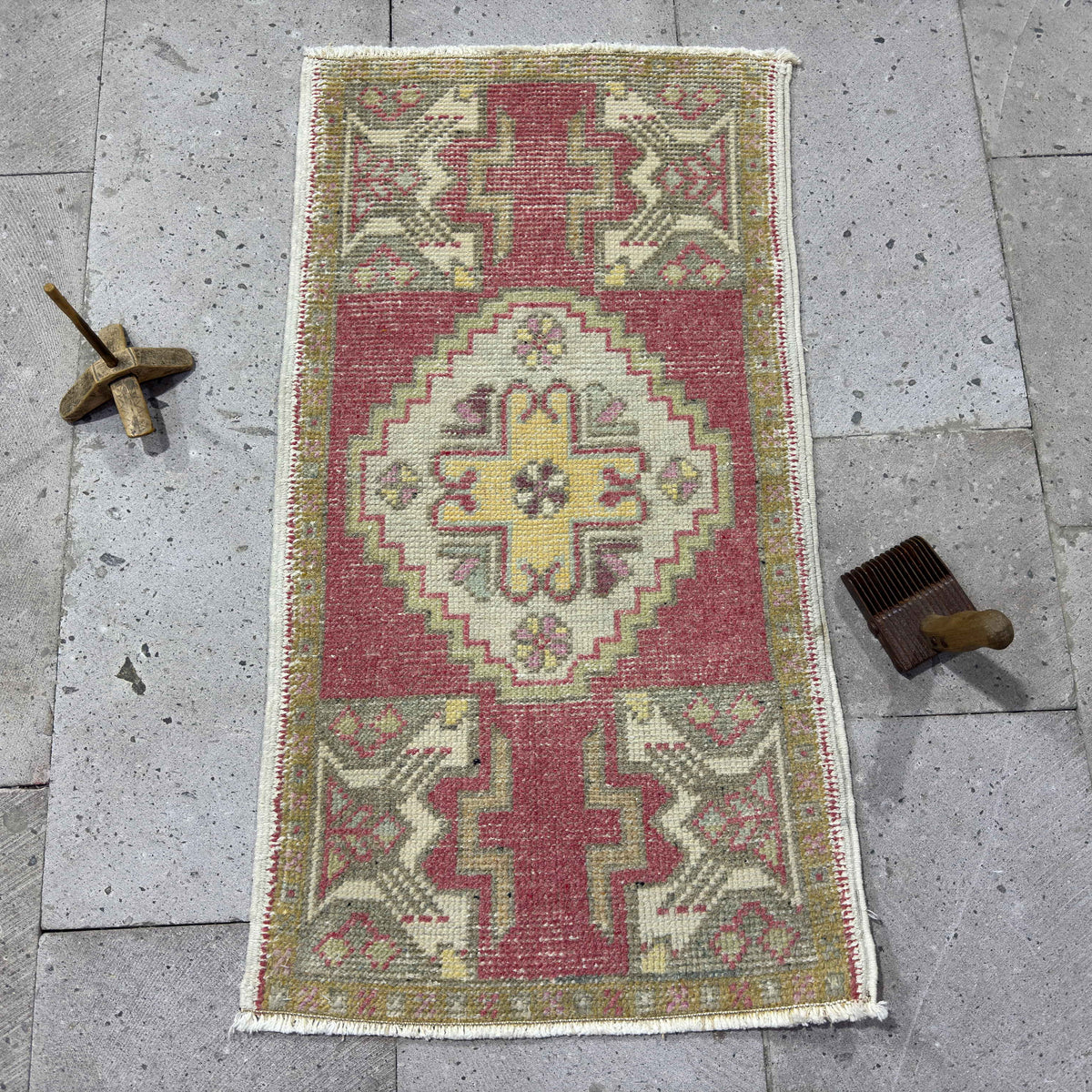Red 2' x 3' vintage turkish rug in wool and cotton, shown on the floor.
