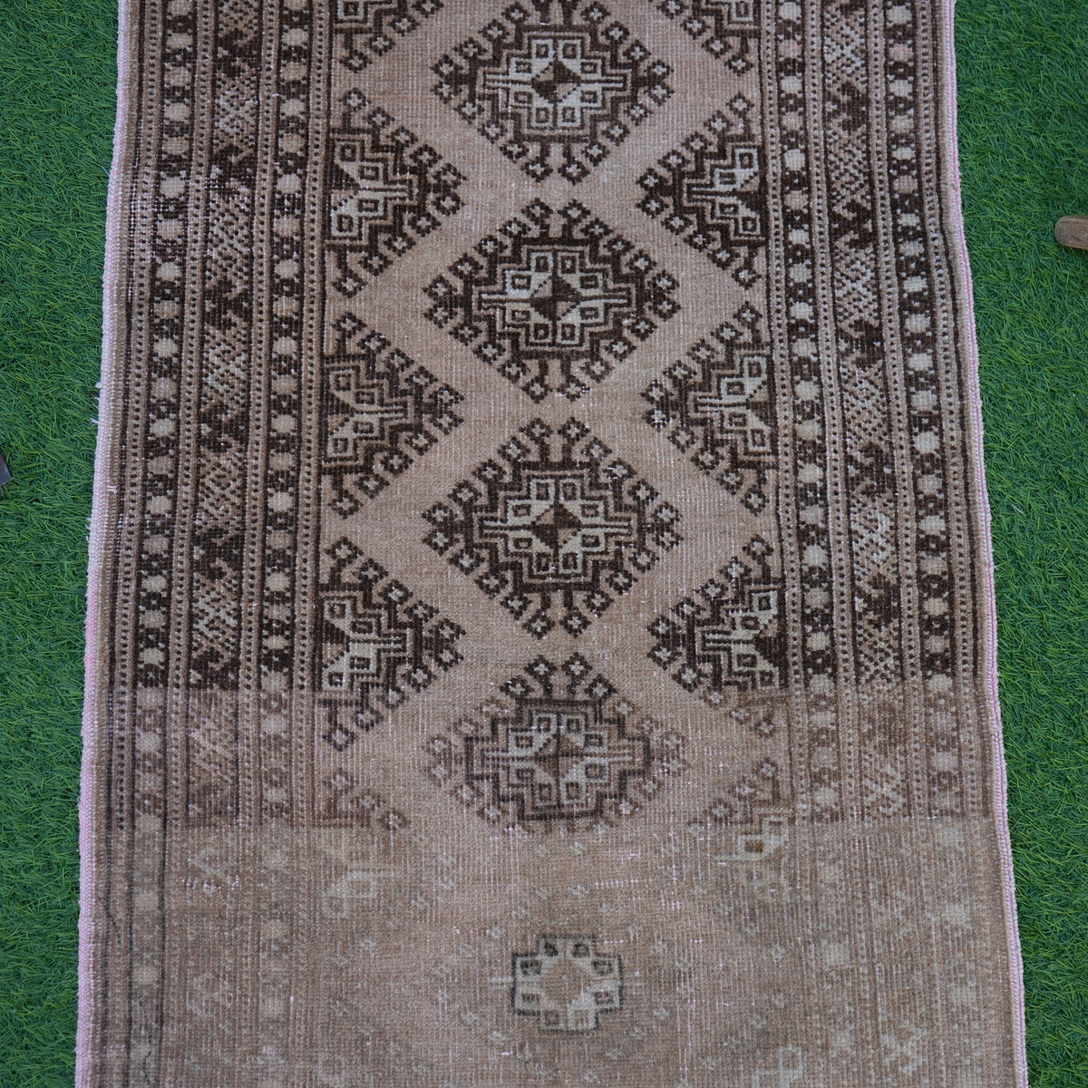 Close-up of the brown vintage turkish rug showing traditional details, hand-knotted weave, wool and cotton and low pile.