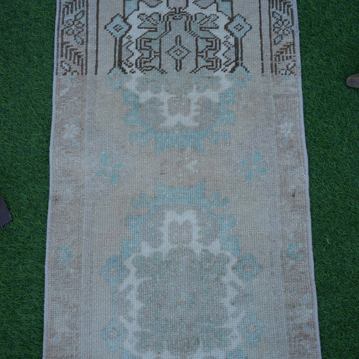 Close-up of the brown vintage turkish rug showing traditional details, hand-knotted weave, wool and cotton and low pile.