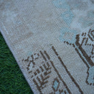 Brown 2' x 4' vintage turkish rug in wool and cotton, shown on the floor.