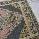 Close-up of the pink vintage turkish rug showing traditional details, hand-knotted weave, wool and cotton and low pile.