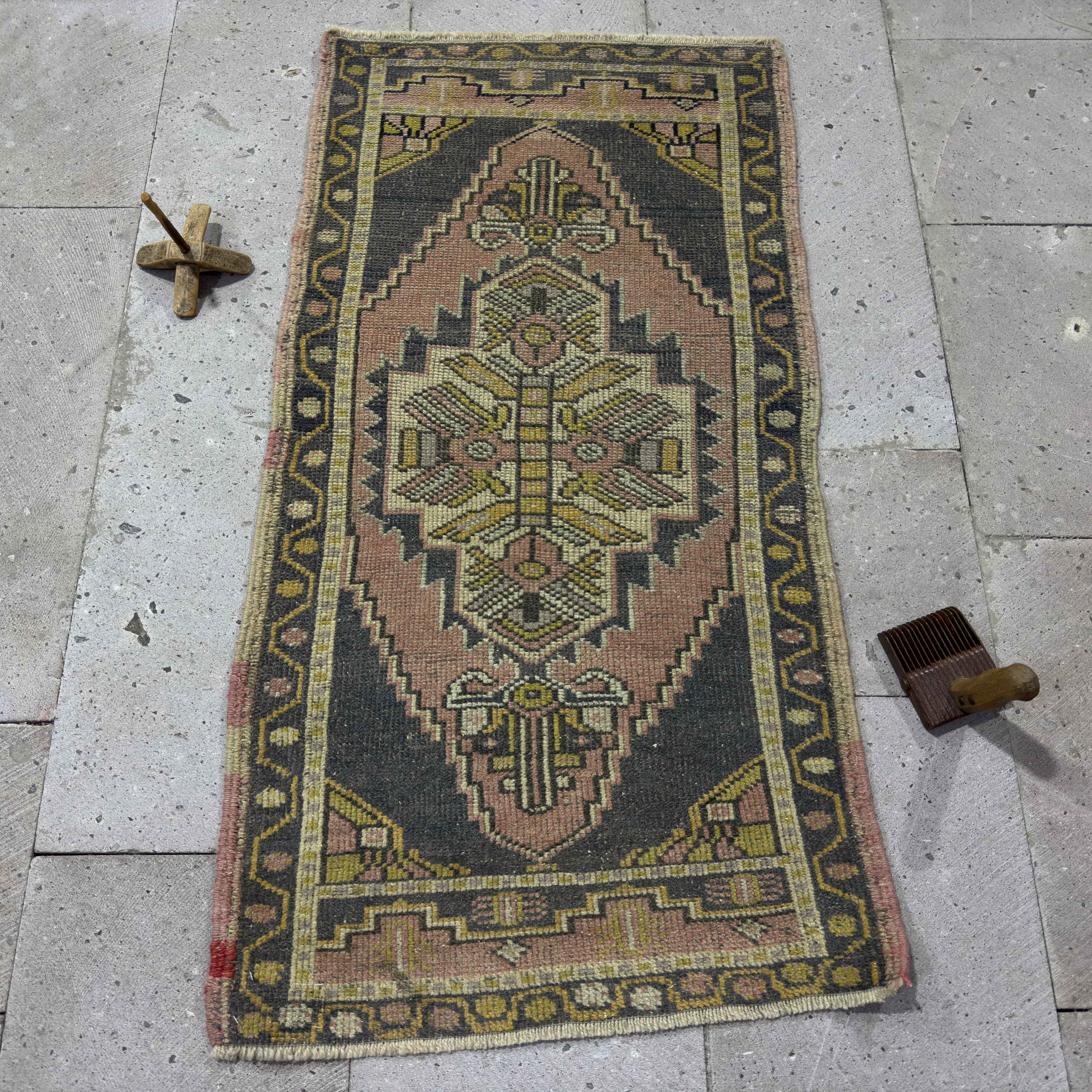 Pink 2' x 4' vintage turkish rug in wool and cotton, shown on the floor.