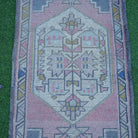 Close-up of the pink vintage turkish rug showing traditional details, hand-knotted weave, wool and cotton and low pile.