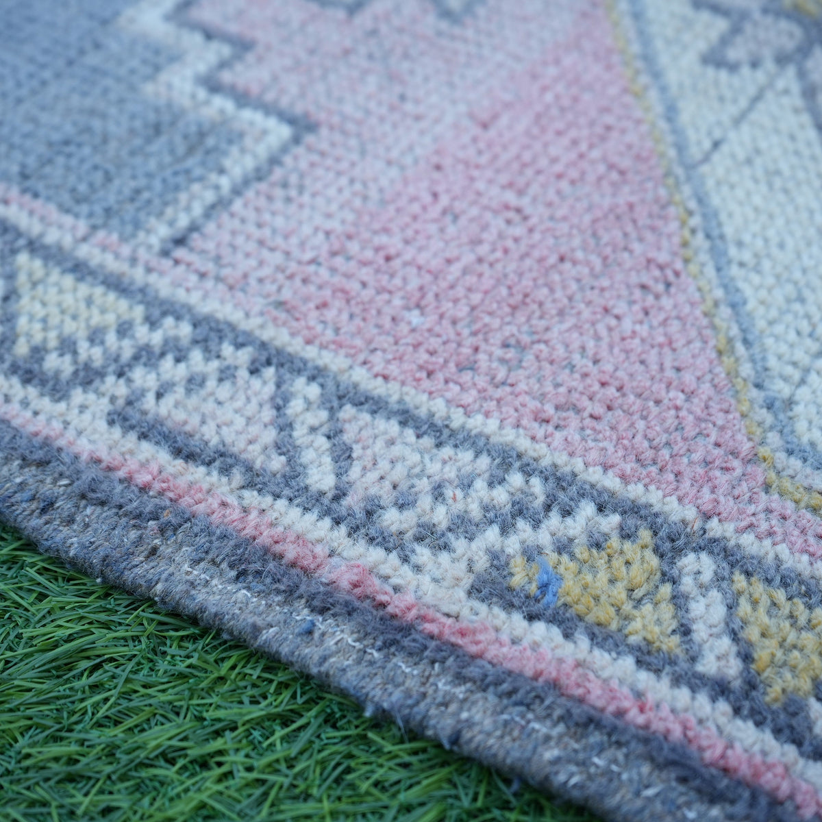 Pink 2' x 4' vintage turkish rug in wool and cotton, shown on the floor.