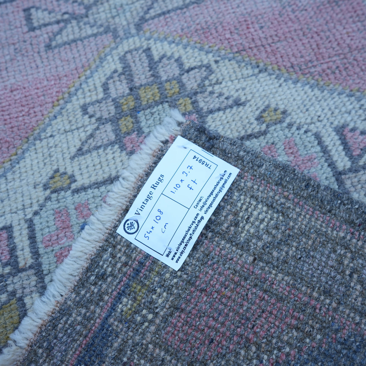 Pink 2' x 4' vintage turkish rug from the 1970s with traditional design.