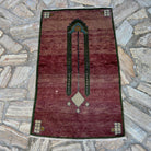 Red 2' x 4' vintage turkish rug in wool and cotton, shown on the floor.