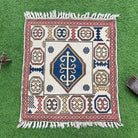 Red 3' x 3' vintage turkish rug in wool and cotton, shown on the floor.