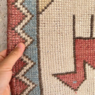Close-up of the red vintage turkish rug showing traditional details, hand-knotted weave, wool and cotton and low pile.
