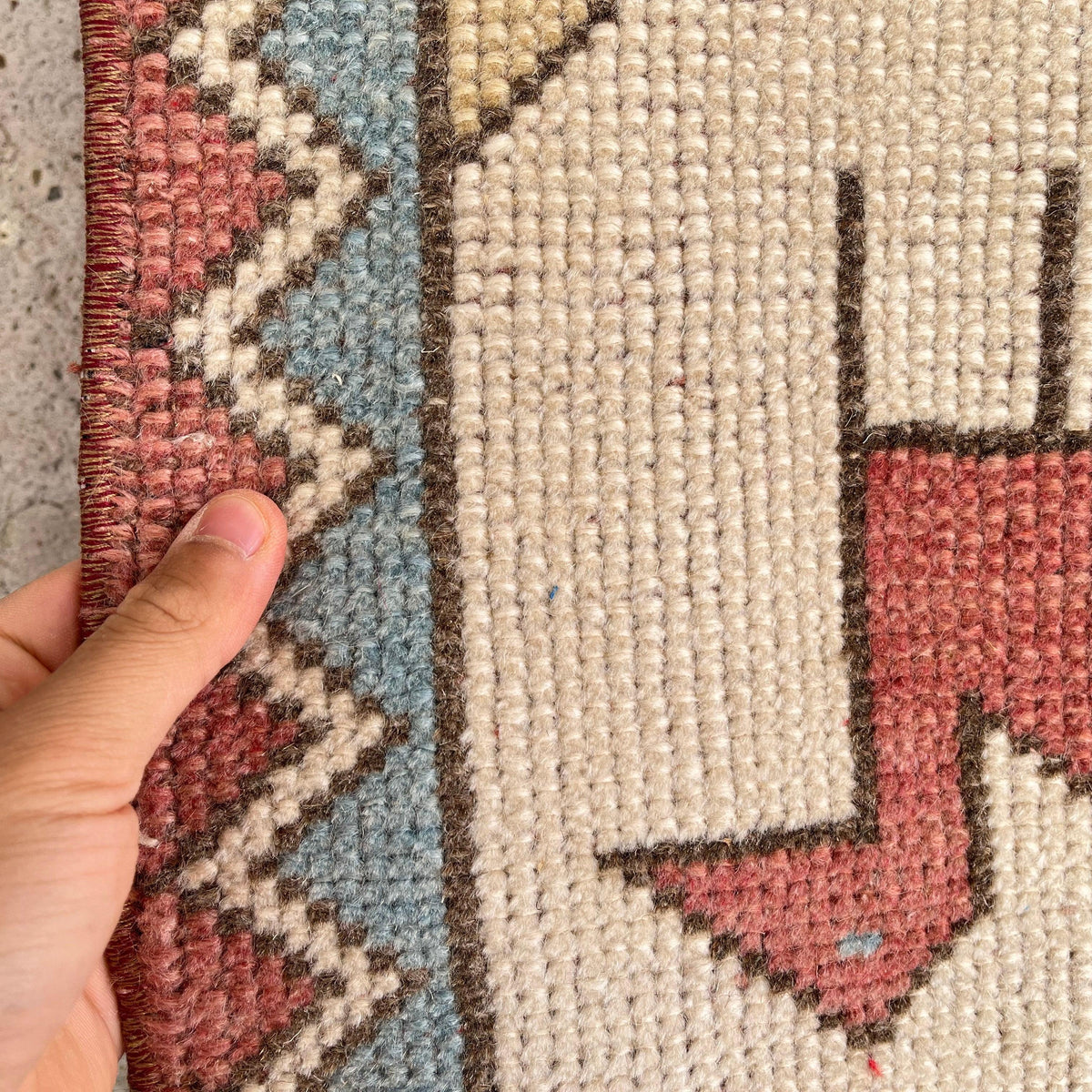 Close-up of the red vintage turkish rug showing traditional details, hand-knotted weave, wool and cotton and low pile.