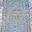 Close-up of the blue vintage turkish rug showing neutral details, hand-knotted weave, wool and low pile.