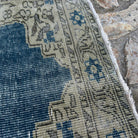 Close-up of the blue vintage turkish rug showing geometric details, hand-knotted weave, wool and cotton and low pile.