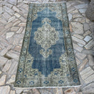 Blue 3' x 6' vintage turkish rug in wool and cotton, shown on the floor.