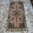 Pink 3' x 6' vintage turkish rug in wool and cotton, shown on the floor.