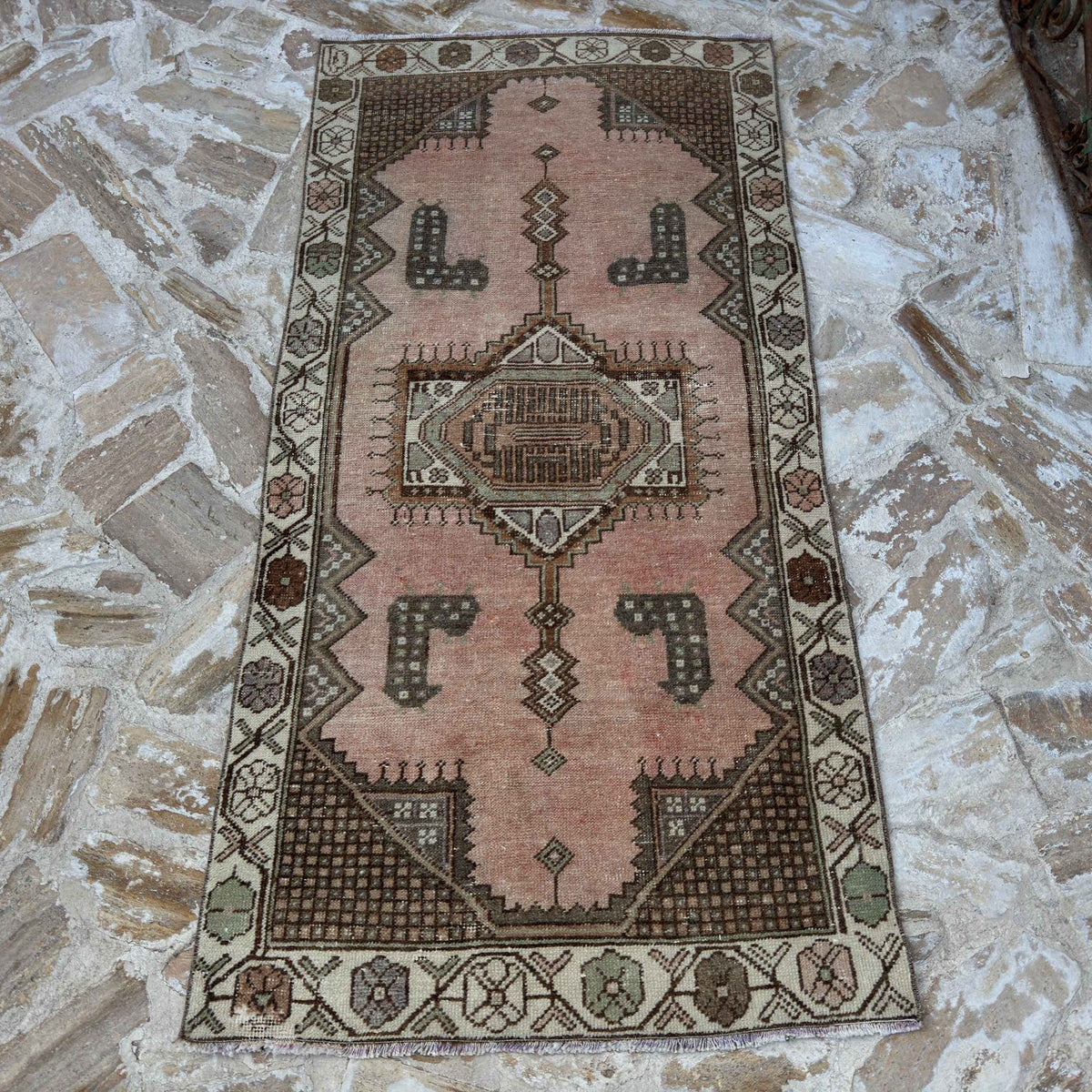 Pink 3' x 6' vintage turkish rug in wool and cotton, shown on the floor.