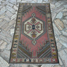 Pink 3' x 6' vintage turkish rug in wool and cotton, shown on the floor.