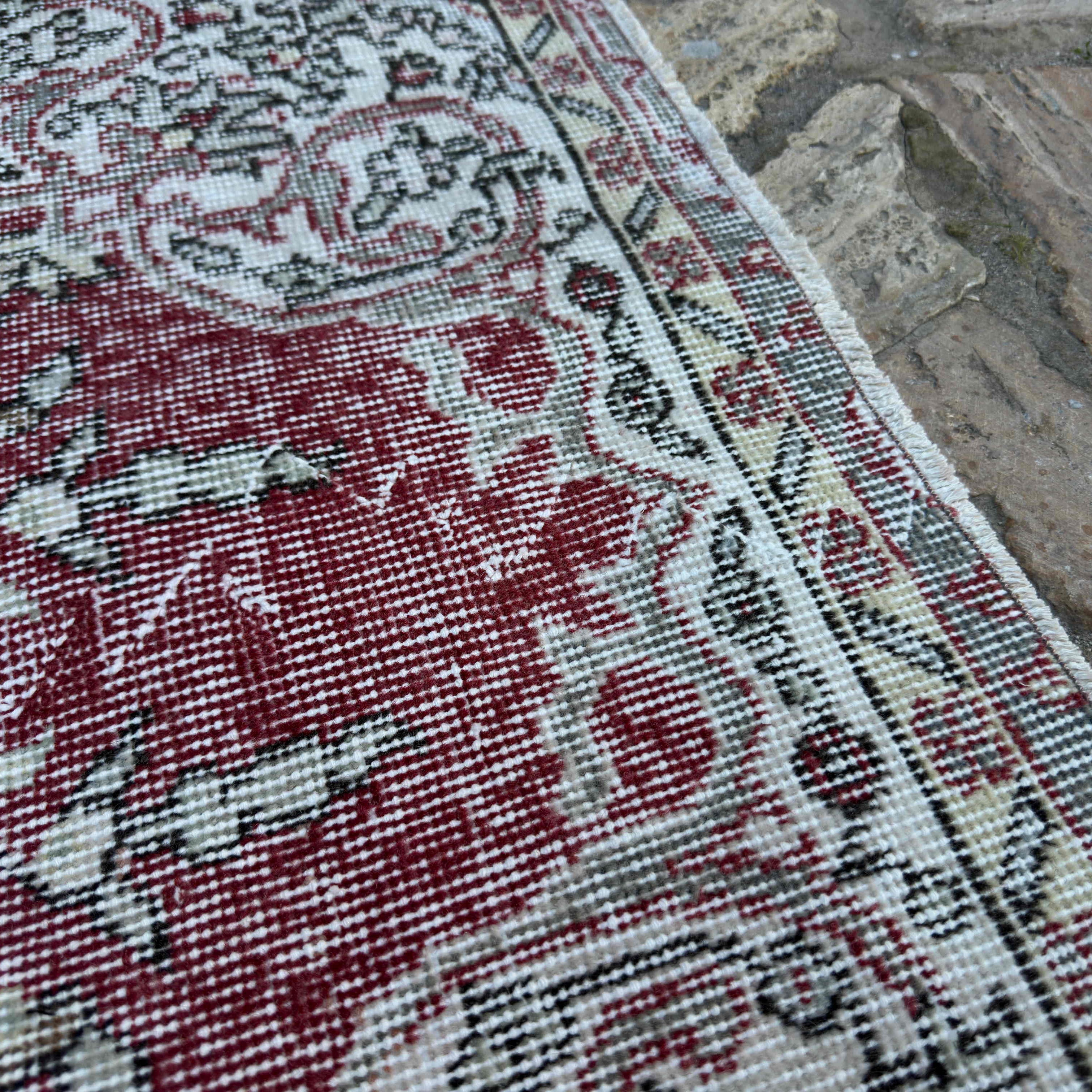 Close-up of the red vintage turkish rug showing traditional details, hand-knotted weave, wool and cotton and low pile.