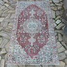 Red 3' x 6' vintage turkish rug in wool and cotton, shown on the floor.