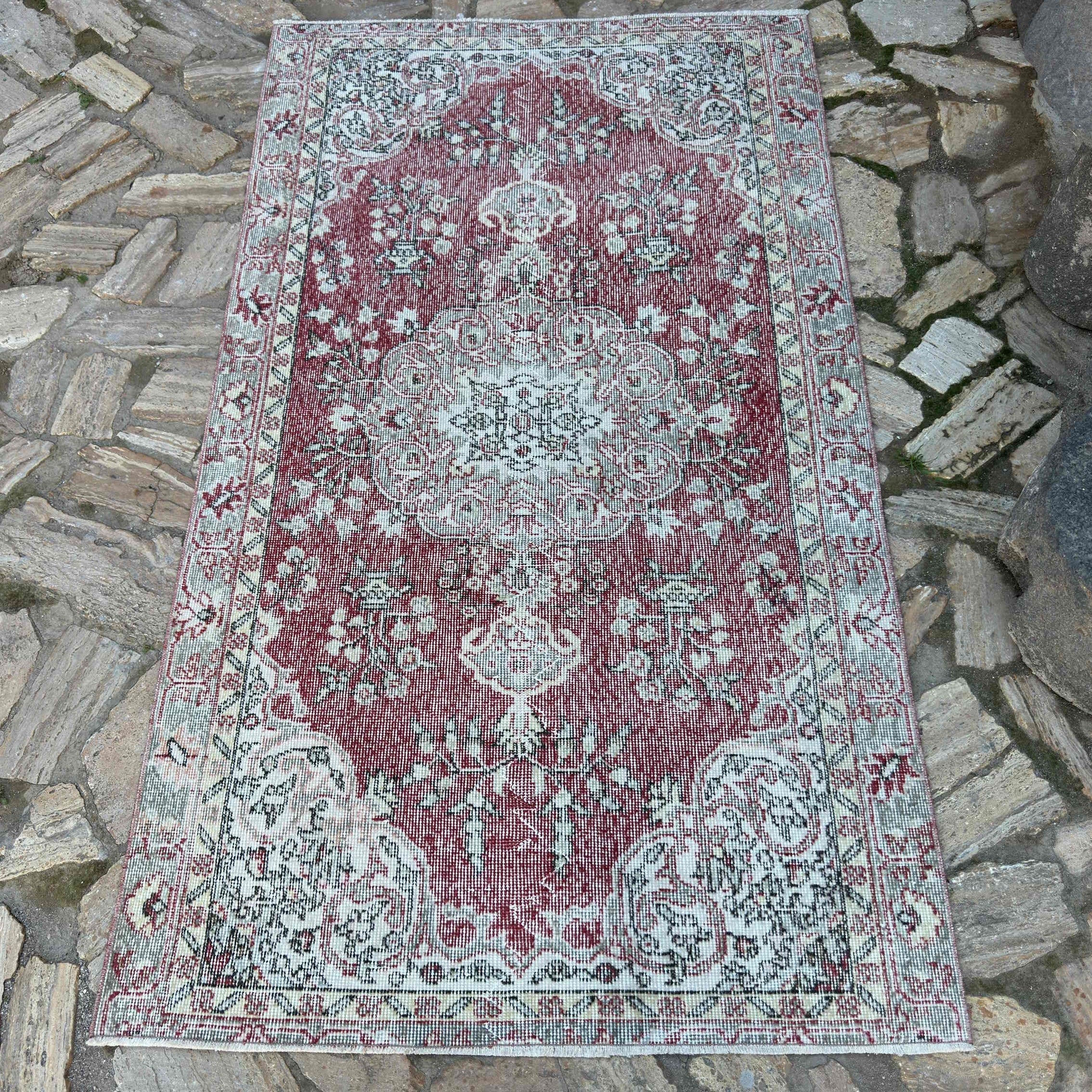 Red 3' x 6' vintage turkish rug in wool and cotton, shown on the floor.