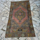 Red 3' x 6' vintage turkish rug in wool and cotton, shown on the floor.