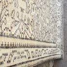 Close-up of the beige vintage turkish rug showing neutral details, hand-knotted weave, wool and cotton and low pile.