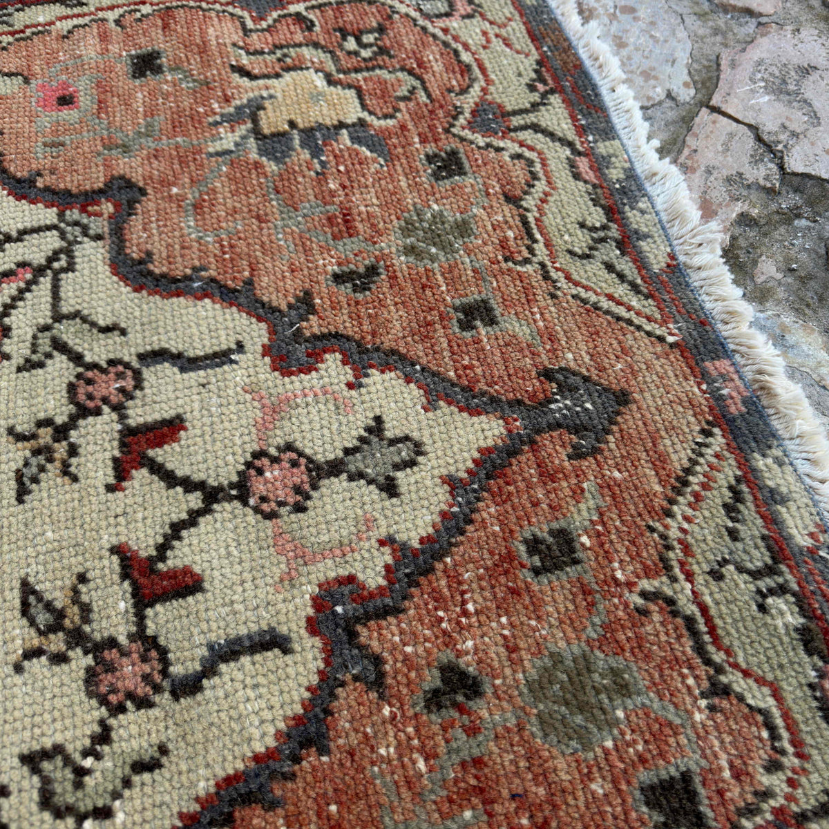 Close-up of the multicolor vintage turkish rug showing geometric details, hand-knotted weave, wool and cotton and low pile.
