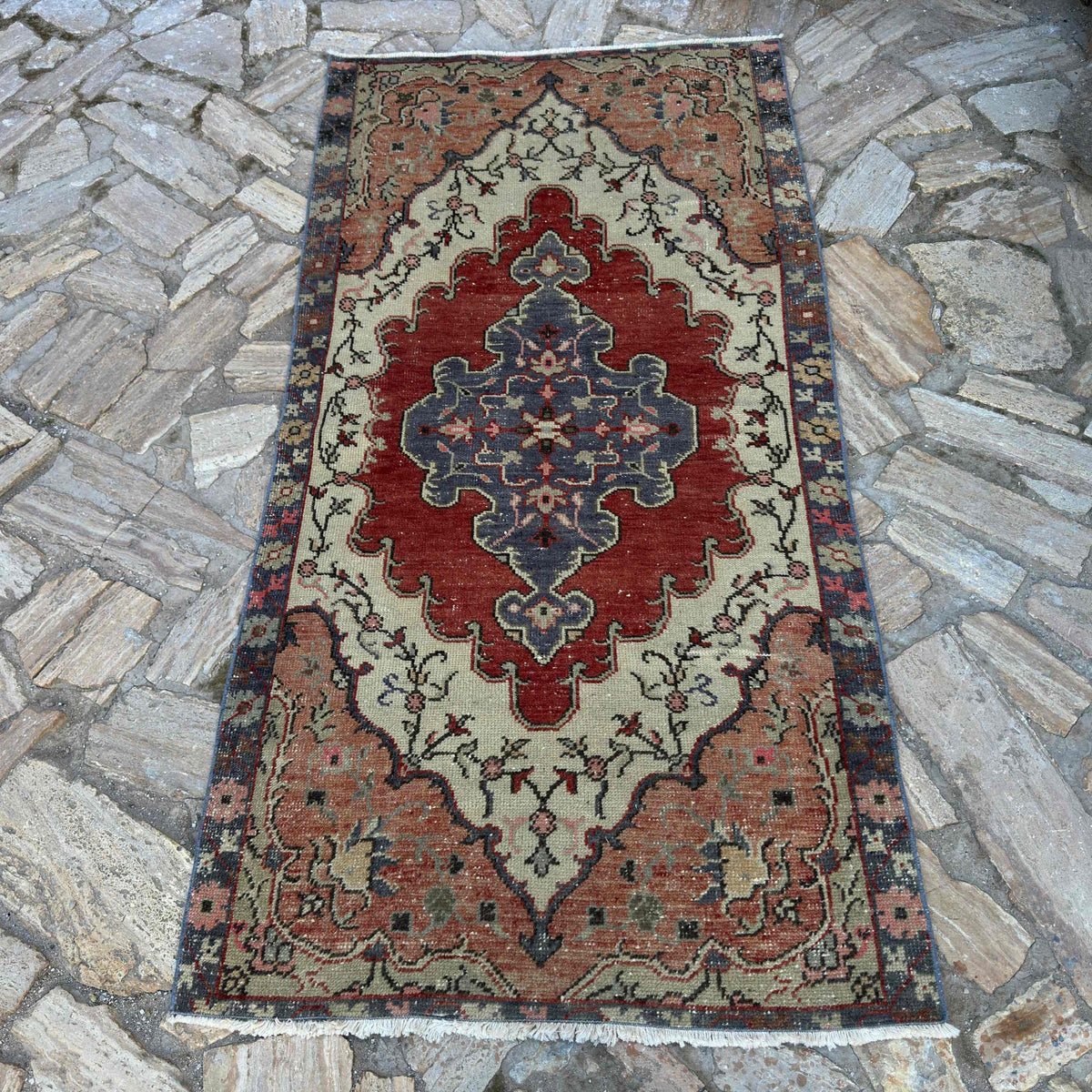 Multicolor 3' x 7' vintage turkish rug in wool and cotton, shown on the floor.