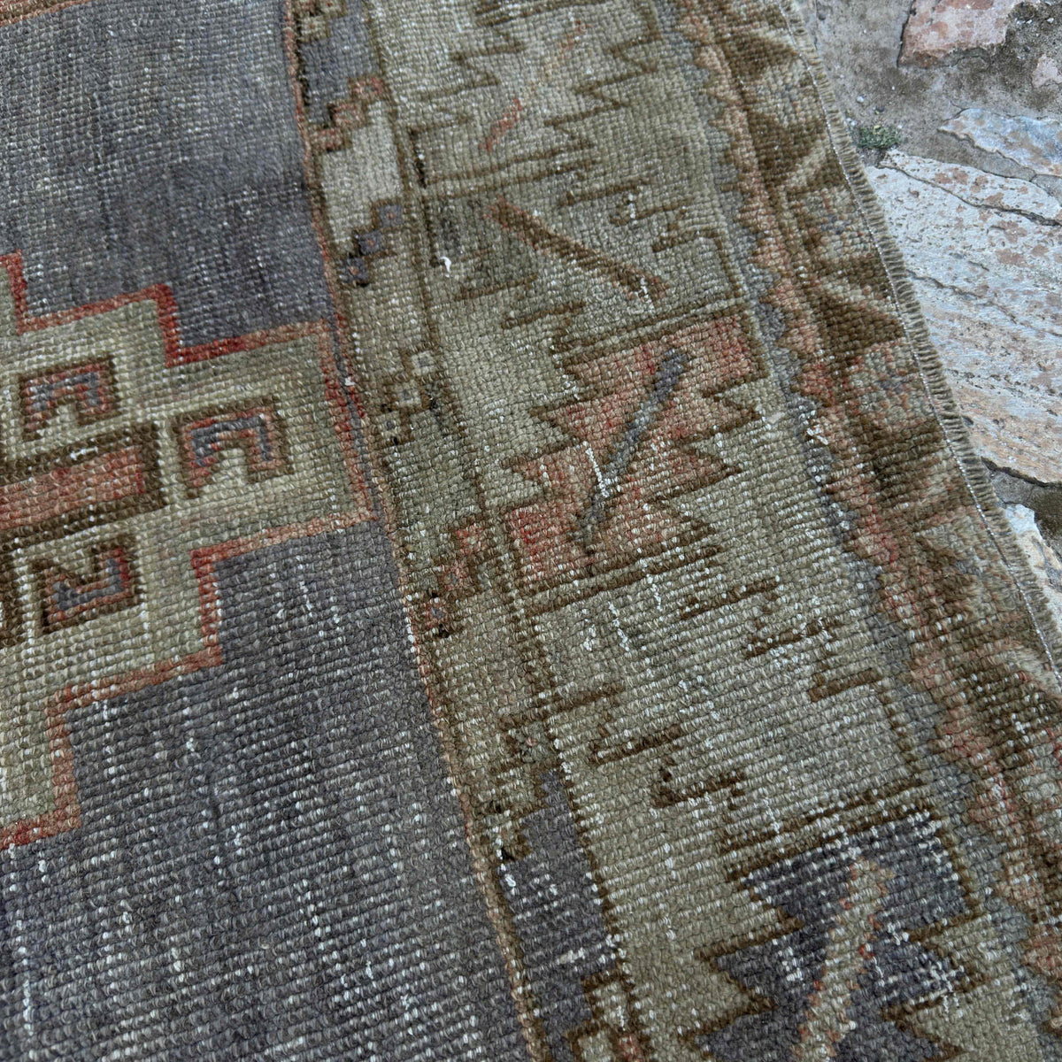 Close-up of the pale red vintage turkish rug showing traditional details, hand-knotted weave, wool and cotton and low pile.