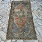 Pale Red 3' x 7' vintage turkish rug in wool and cotton, shown on the floor.
