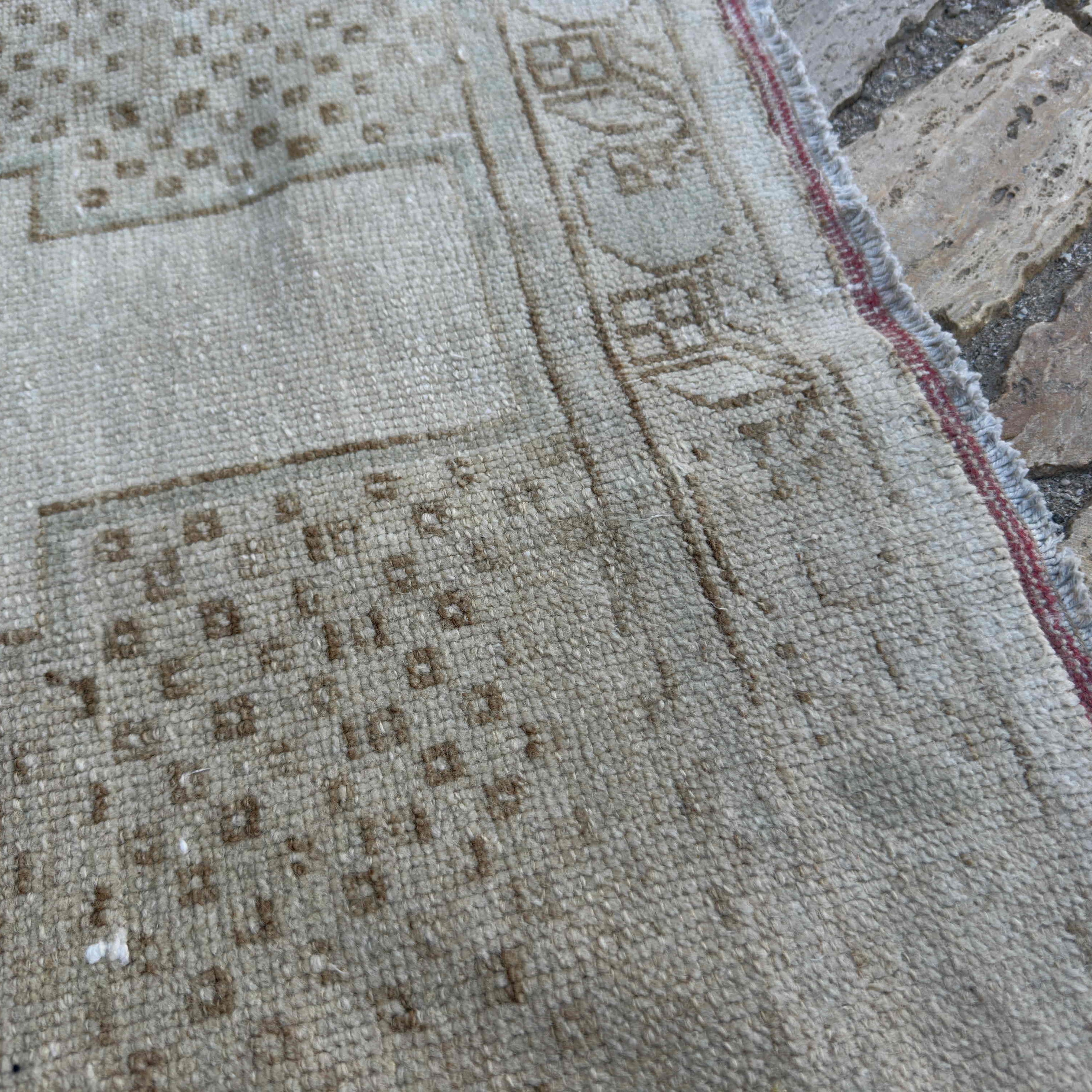 Close-up of the brown vintage turkish rug showing neutral details, hand-knotted weave, wool and cotton and low pile.