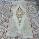 Brown 3' x 8' vintage turkish rug in wool and cotton, shown on the floor.