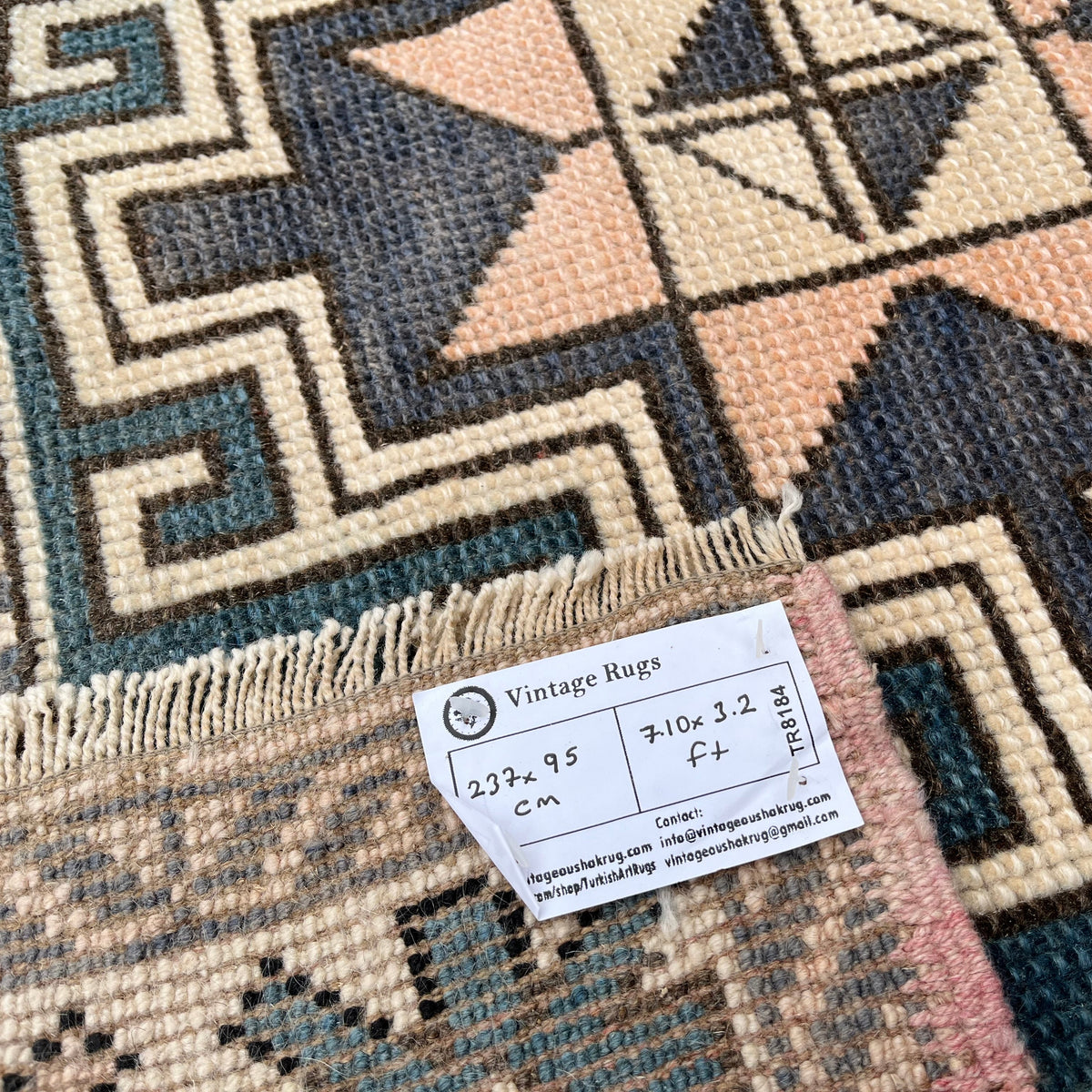 Close-up of the pink vintage turkish rug showing oushak details, hand-knotted weave, wool and cotton and low pile.