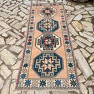 Pink 3' x 8' vintage turkish rug in wool and cotton, shown on the floor.
