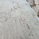 Close-up of the beige vintage turkish rug showing geometric details, hand-knotted weave, wool and cotton and low pile.