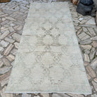 Beige 4' x 10' vintage turkish rug in wool and cotton, shown on the floor.