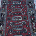Close-up of the red vintage turkish rug showing geometric details, hand-knotted weave, wool and low pile.