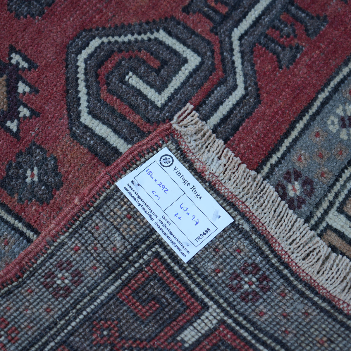 Red 4' x 10' vintage turkish rug from the 1970s with geometric design.